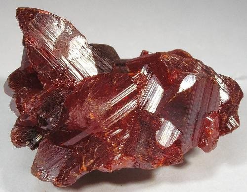 Raw realgar crystals, a red orange arsenic sulfide mineral Raw realgar crystals, a red orange arsenic sulfide mineral