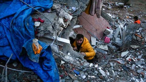 A man searches for people in a destroyed building in Adana, Turkey, Monday, Feb. 6, 2023. A powerful quake has knocked down multiple buildings in southeast Turkey and Syria and many casualties are feared. (AP Photo/Khalil Hamra) A man searches for people in a destroyed building in Adana, Turkey, Monday, Feb. 6, 2023. A powerful quake has knocked down multiple buildings in southeast Turkey and Syria and many casualties are feared. (AP Photo/Khalil Hamra)