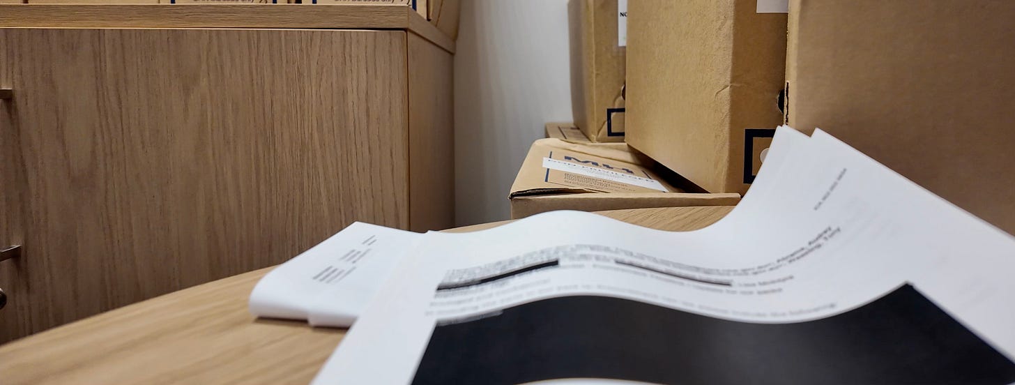 Image of papers on desk with redacted text