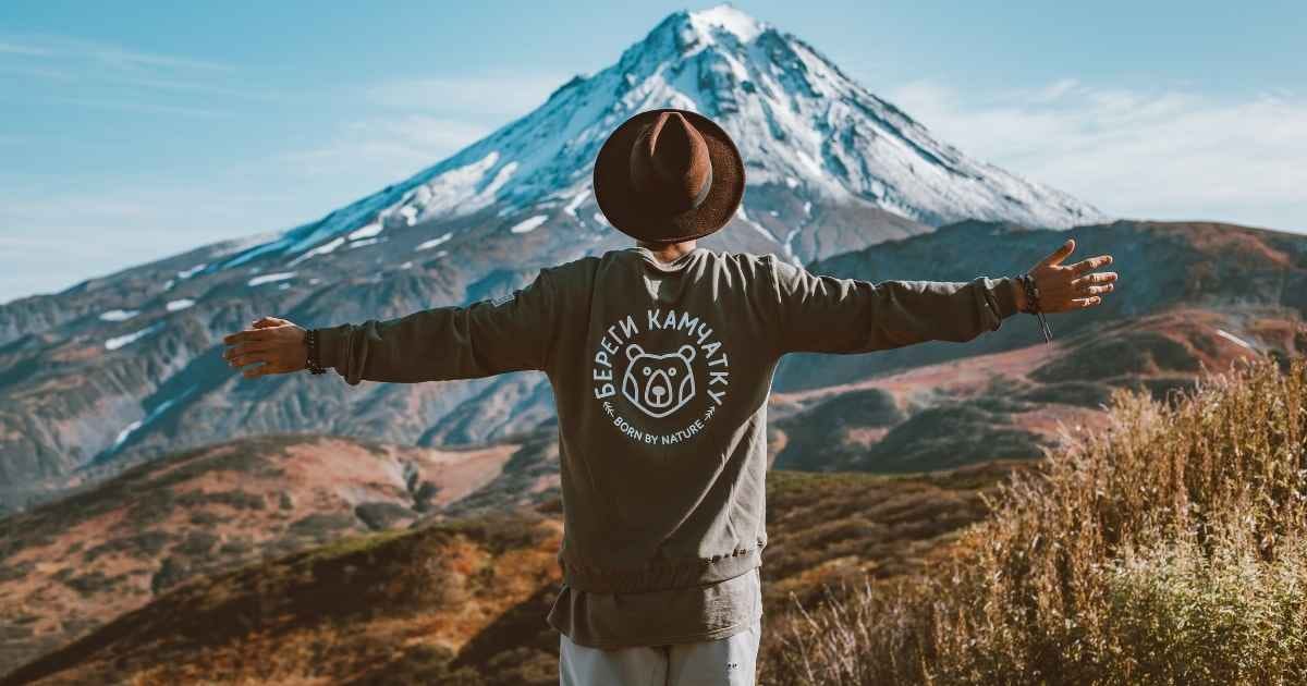 traveller in hat admiring distant mountain