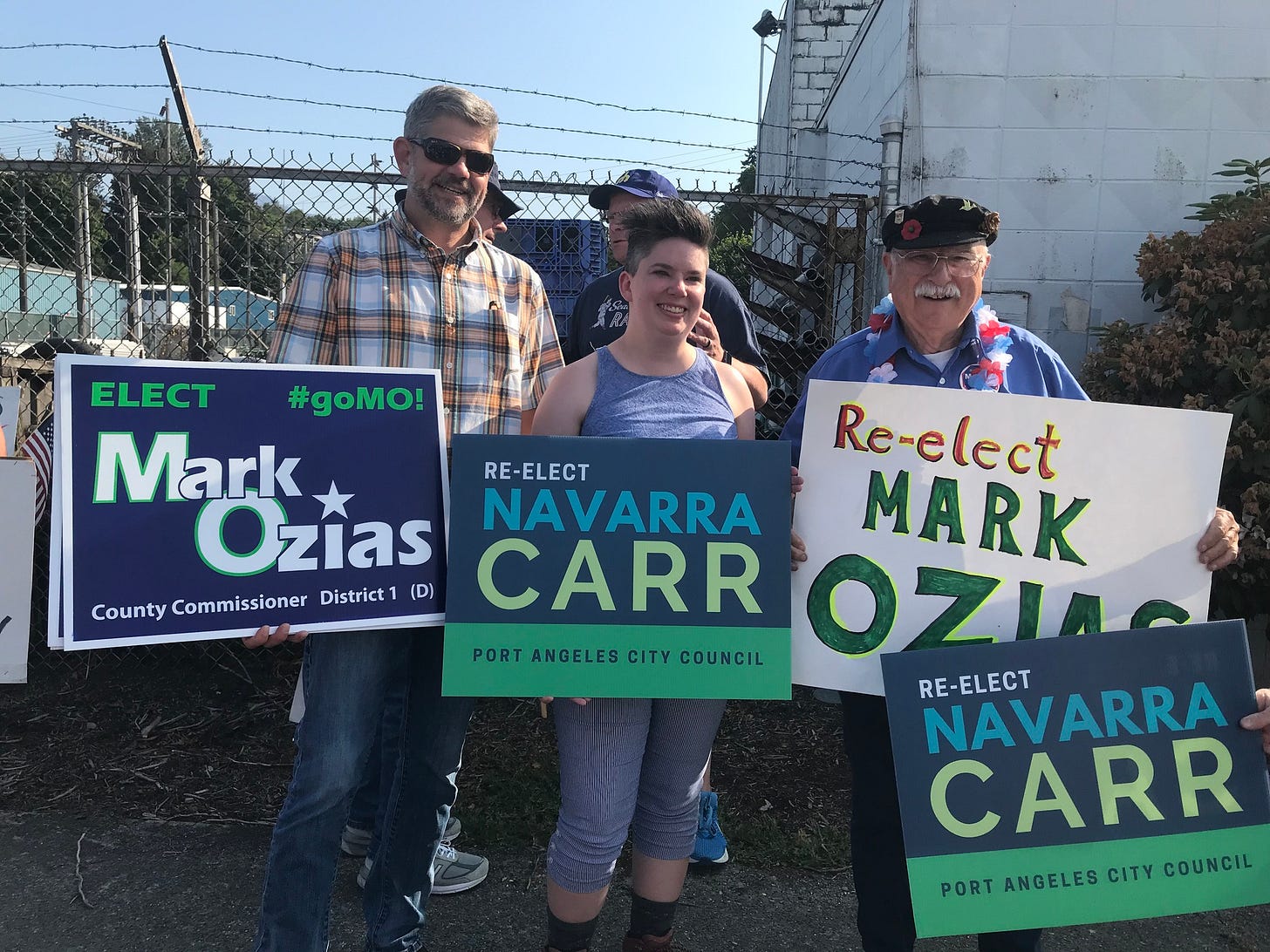 May be an image of 3 people and text that says 'ELECT #goMO! Mark RE RE-ELECT Ozias NAVARRA Relek County Commissioner District (D) CARR OZILO PORTANGELES PRT PORT CITY COUNCIL RE-ELECT NAVARRA CARR PORT ANGELES CITY COUNCIL'