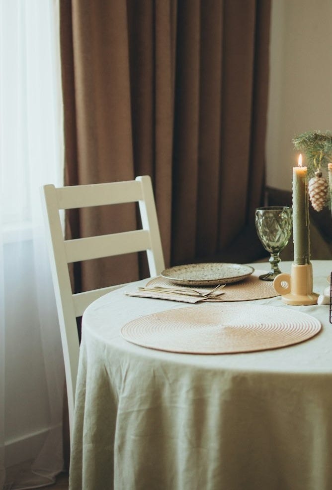 An empty chair sits near a softly lit Christmas tree, capturing the quiet tenderness of the season