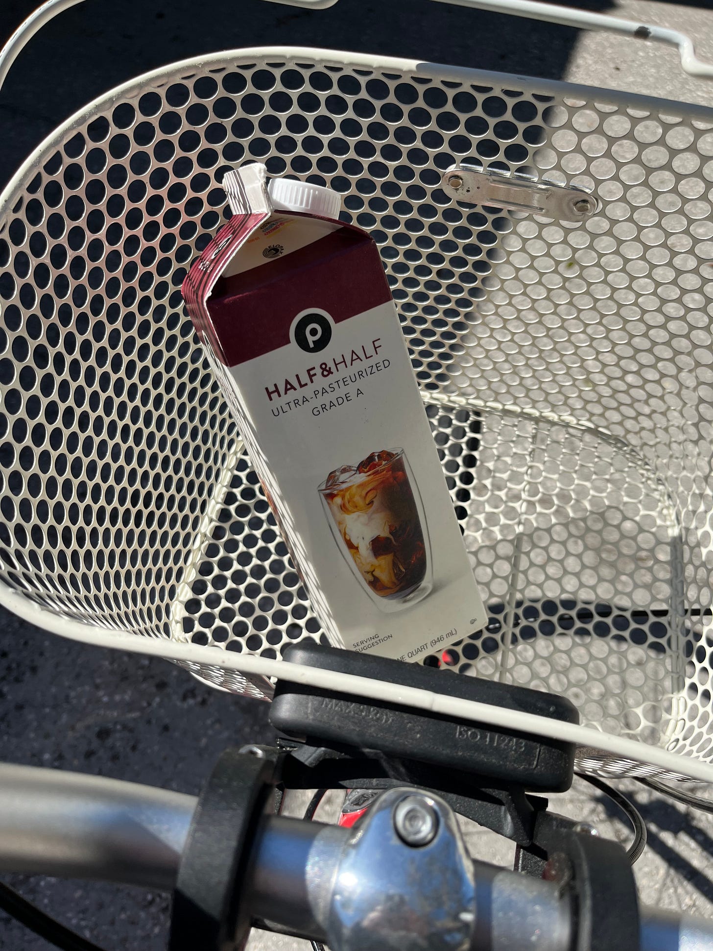 Photo of my bike basket with a single carton of half-and-half
