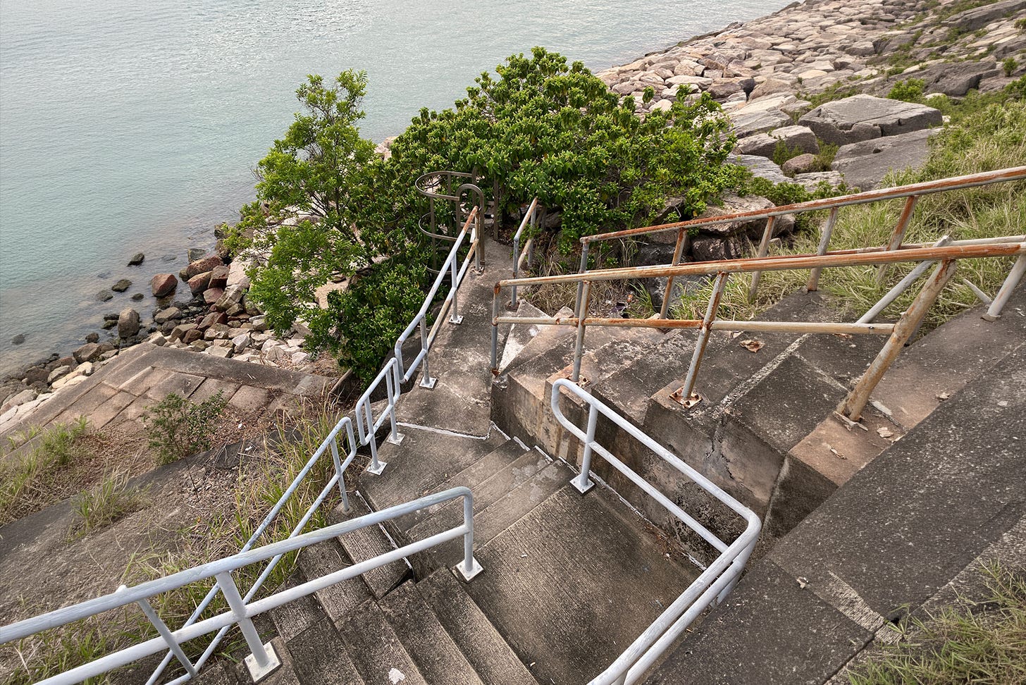 Multiple stairs at odd angles heading down to an observation point of a lake
