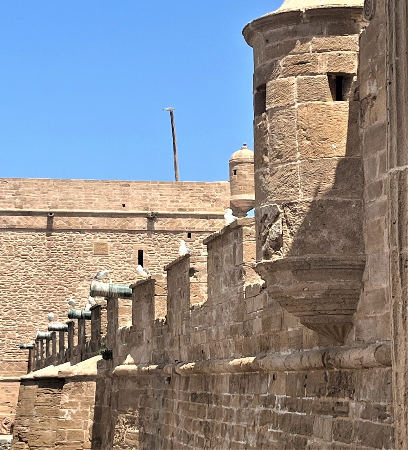 A stone wall with a tower

Description automatically generated
