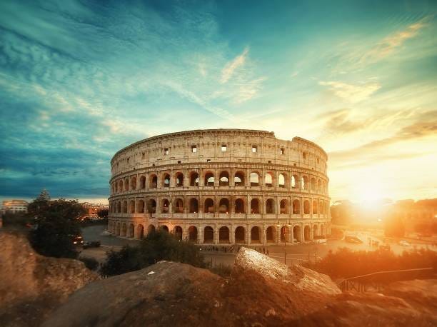 Beautiful shot of the famous Roman Colosseum amphitheater under the breathtaking sky at sunrise A beautiful shot of the famous Roman Colosseum amphitheater under the breathtaking sky at sunrise colosseum sunrise stock pictures, royalty-free photos & images