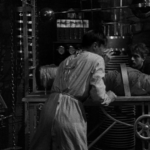 Colin Clive as Henry Frankenstein turns away from the monster, just brought to life in his laboratory - an animated gif