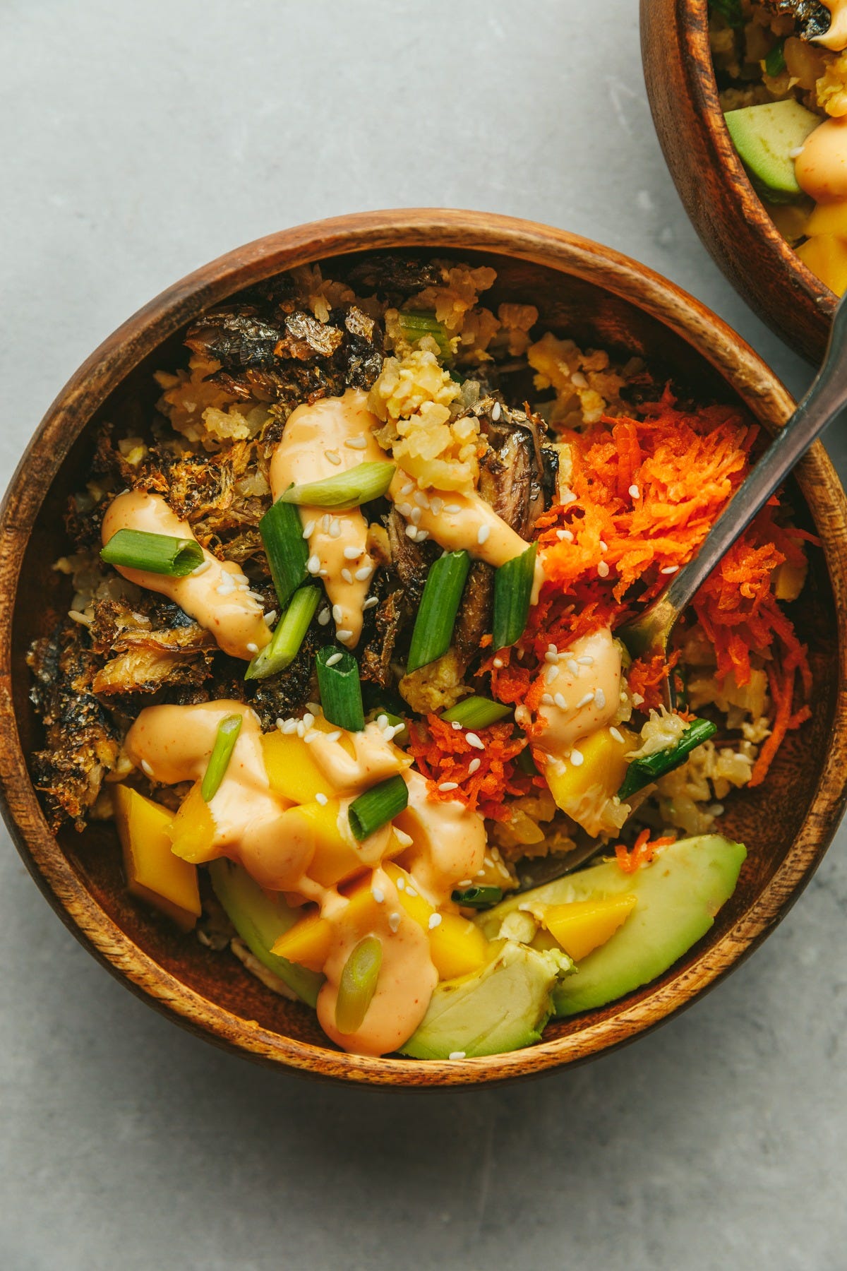 Crispy sardine fried rice with sushi toppings in a wooden bowl.
