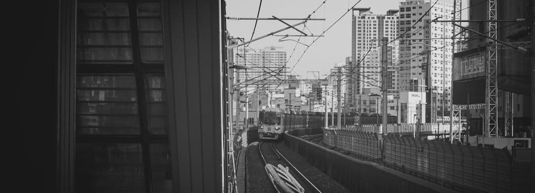 a black and white photo of a train coming down the tracks