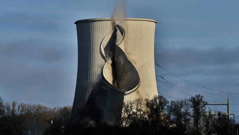 A cooling tower of the former Biblis nuclear power plant collapses after being destabilised while a last one is still standing in Biblis, Germany, Thursday, Dec. 11, 2025.