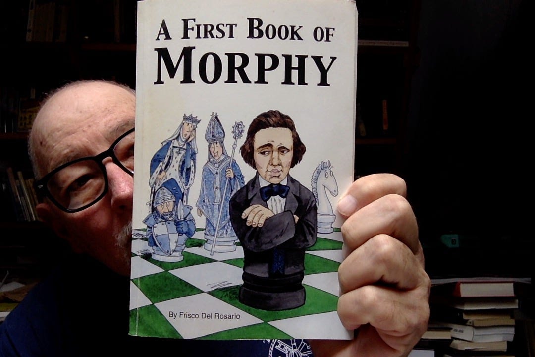 Photo of some old bald dude peering out from behind a copy of Frisco Del Rosario's "A First Book of Morphy"