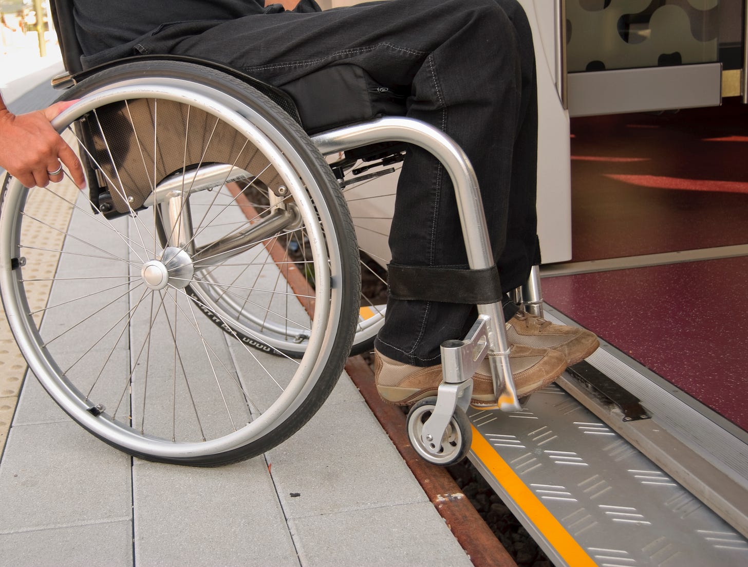 Wheelchair user enters a train with level boarding.