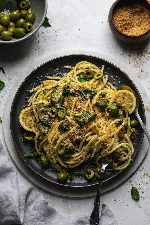 Overhead shot of olive pasta on a dark plate Overhead shot of olive pasta on a dark plate