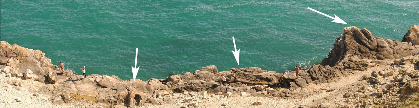 yellowish rocks with three tree-shaped cavities; greenish sea