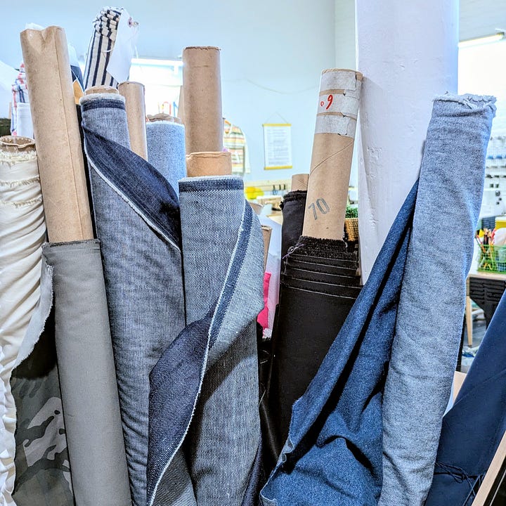 Bolts of denim and a pair of jeans in progress