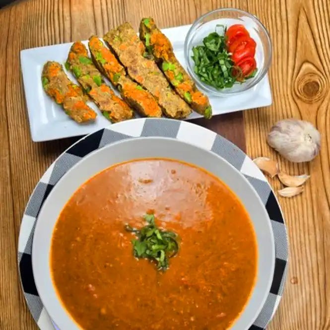 Creamy tomato basil soup in a white bowl birds-eye-view