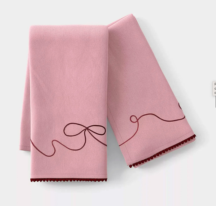 Pink tea towels, a daffodil serving platter, ceramic berry bowls, and a scalloped wooden cutting board.