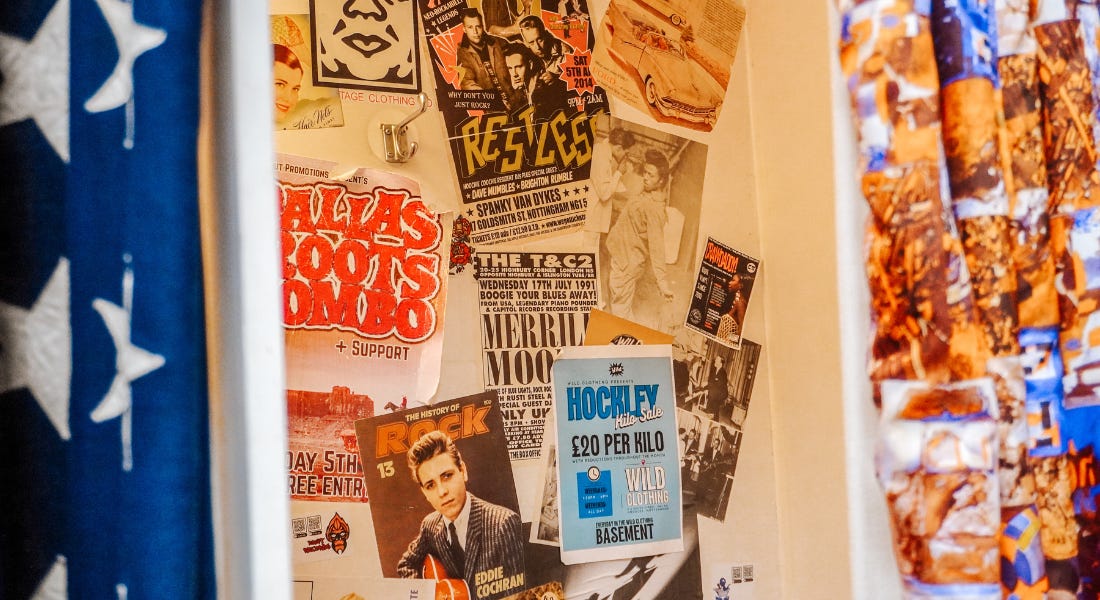 A close-up of a changing room with an American flag curtain and posters stuck inside