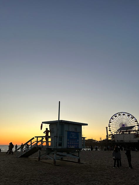 the pier sign, the pacific park sign, the end of route 66 sign, and the sun setting and rising over the pier
