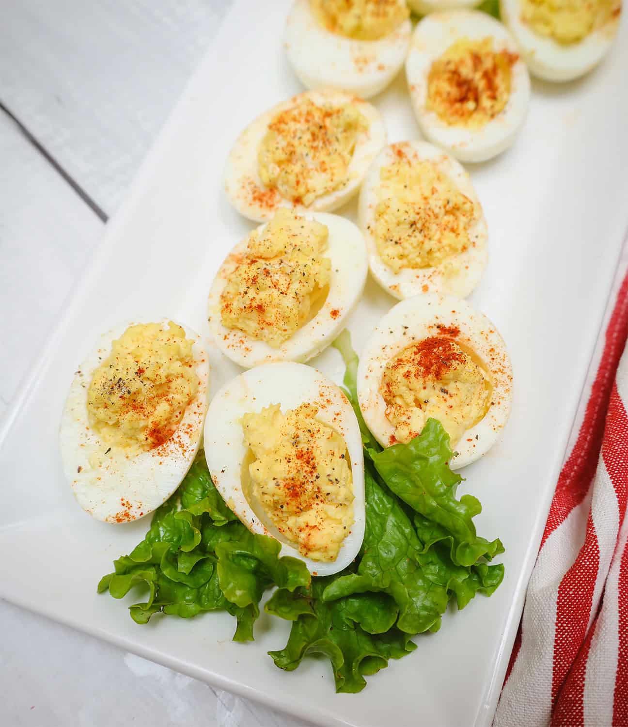 Black Southern deviled eggs arranged on a white platter with lettuce garnish and sprinkled with paprika, a classic soul food side dish often served for Easter, cookouts, and Juneteenth gatherings