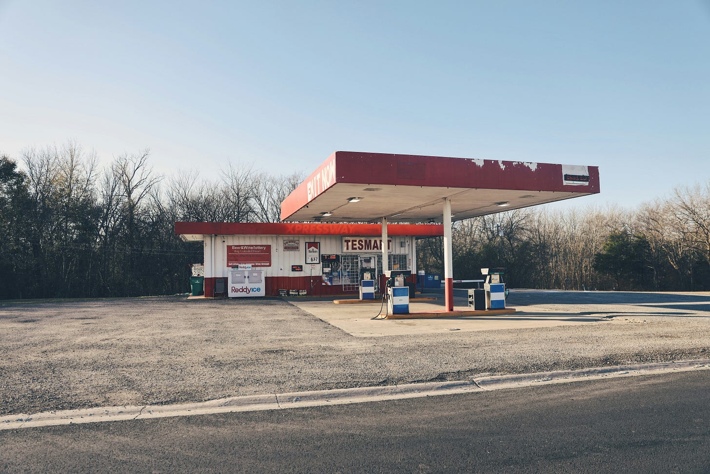 A gas station with two pumps and red roof.