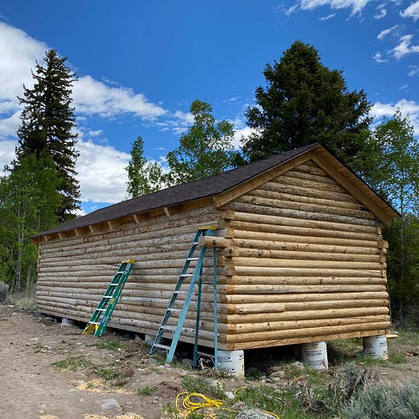 log cabin in various stages of completion.