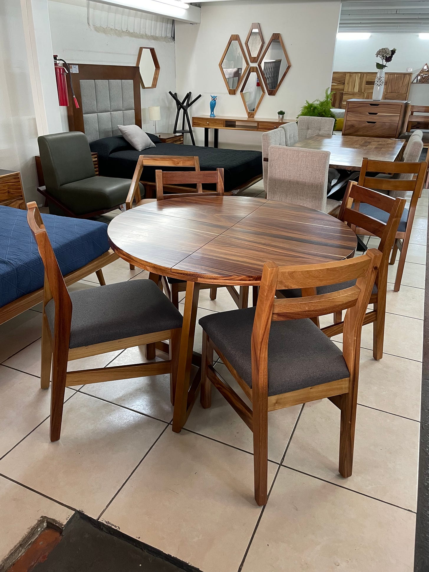 A table and chairs sitting in a furniture showroom, surrounded by other furniture.