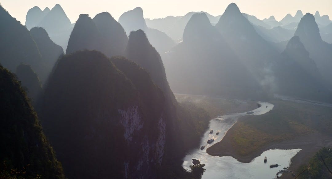silhouette of rock formation and river during daytime