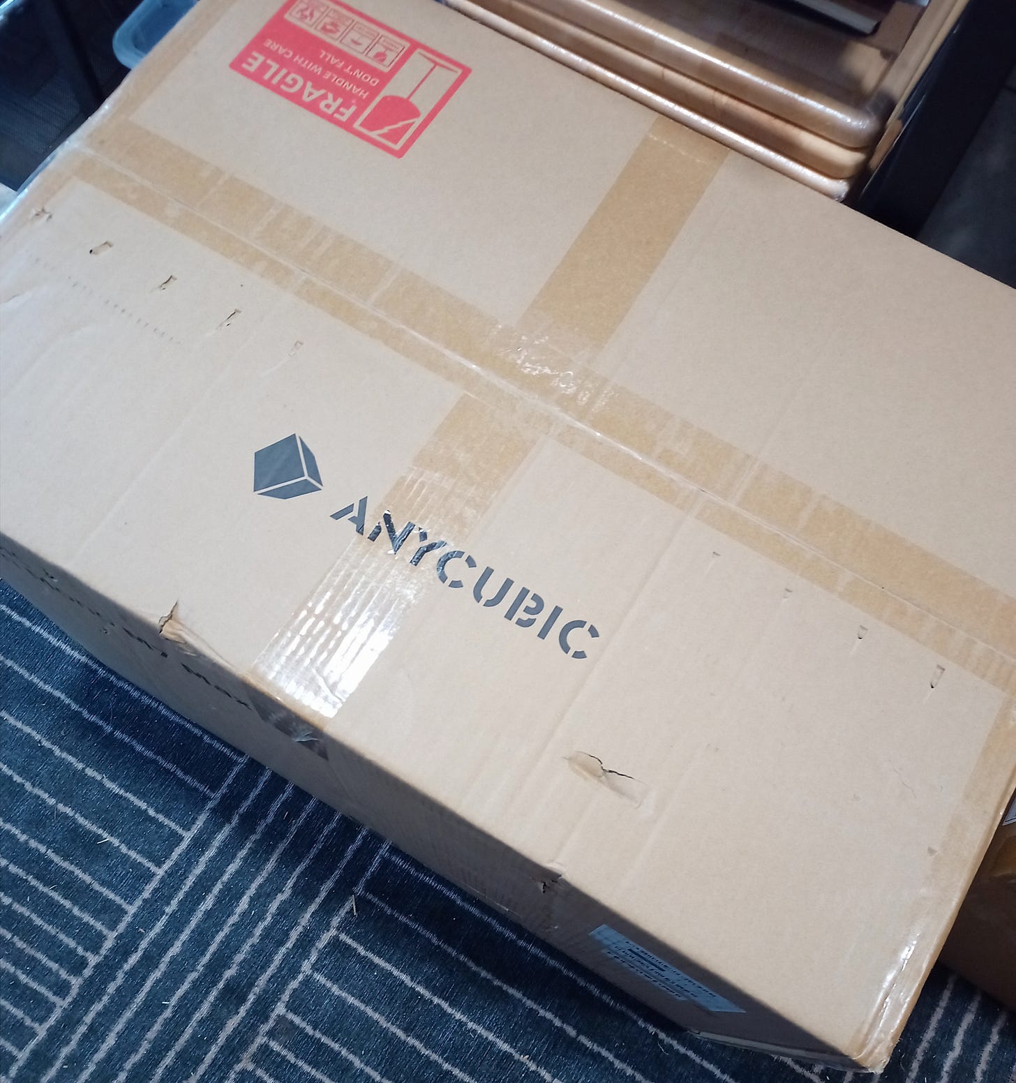 A large cardboard shipping box with the Anycubic logo on top.