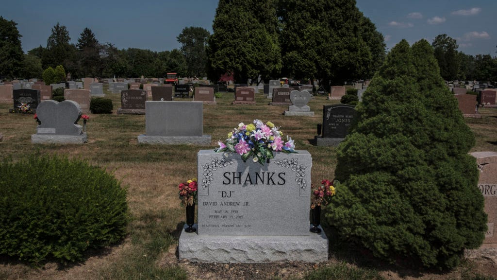 Graveyard memorial for overdose victims with flowers on tombstone