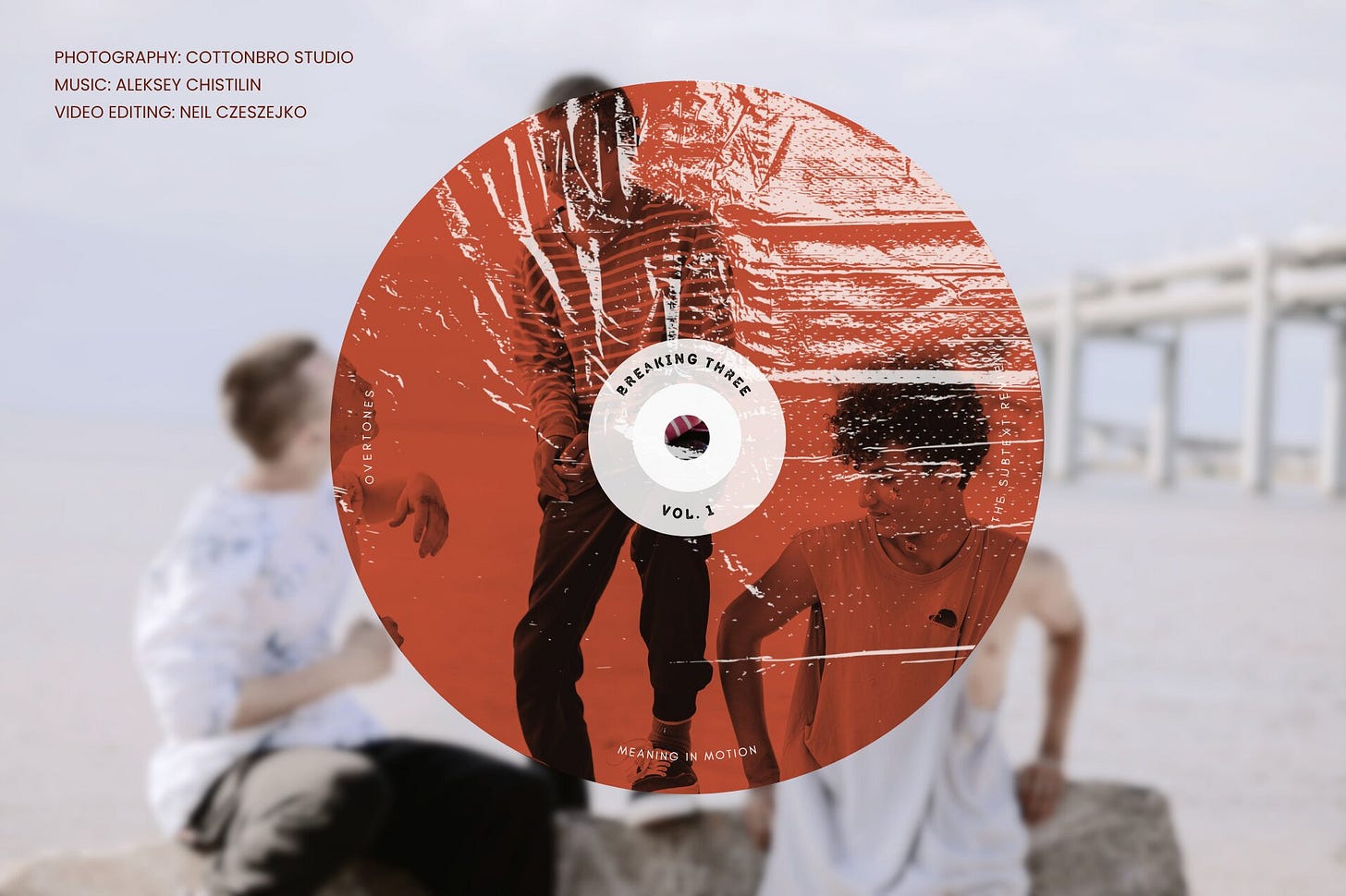 Cover image featuring a textured compact disc graphic tinted terracotta red with the text "Breaking Three, Vol. 1." The disc overlays a desaturated photograph of three teenage boys talking animatedly with the sea behind them. In the upper-left corner, the metadata text reads: "PHOTOGRAPHY: cottonbro studio, MUSIC: Aleksey Chistilin, VIDEO EDITING: Neil Czeszejko." Part of the Overtones series at The Subtext Review.