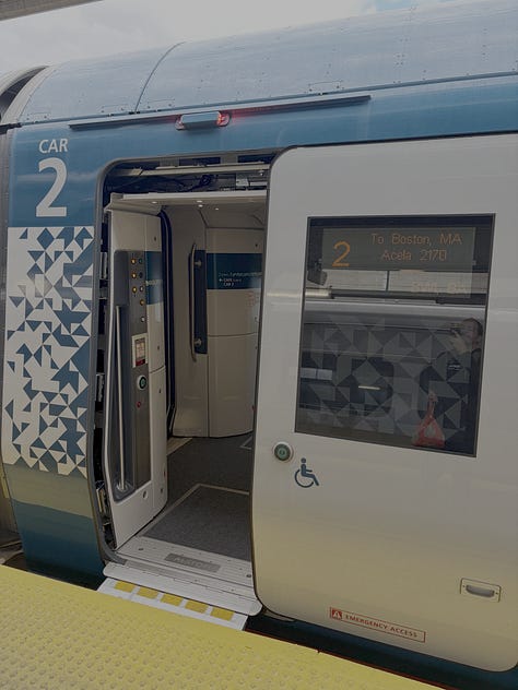 Photo 1: a door to "Car 2" opens with a sign indicating that the train is bound for Boston, with the accessible markers; photo 2: an accessible restroom with a toilet, grab bars, sink, mirrors, and automatic door with a close/open button; 3. A train interior with a clear area, a table, and seats in two directions, with signposts at each row on the seat cushion