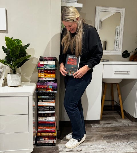 Pic: Melissa beside the stack of books she has read to date in 2024
