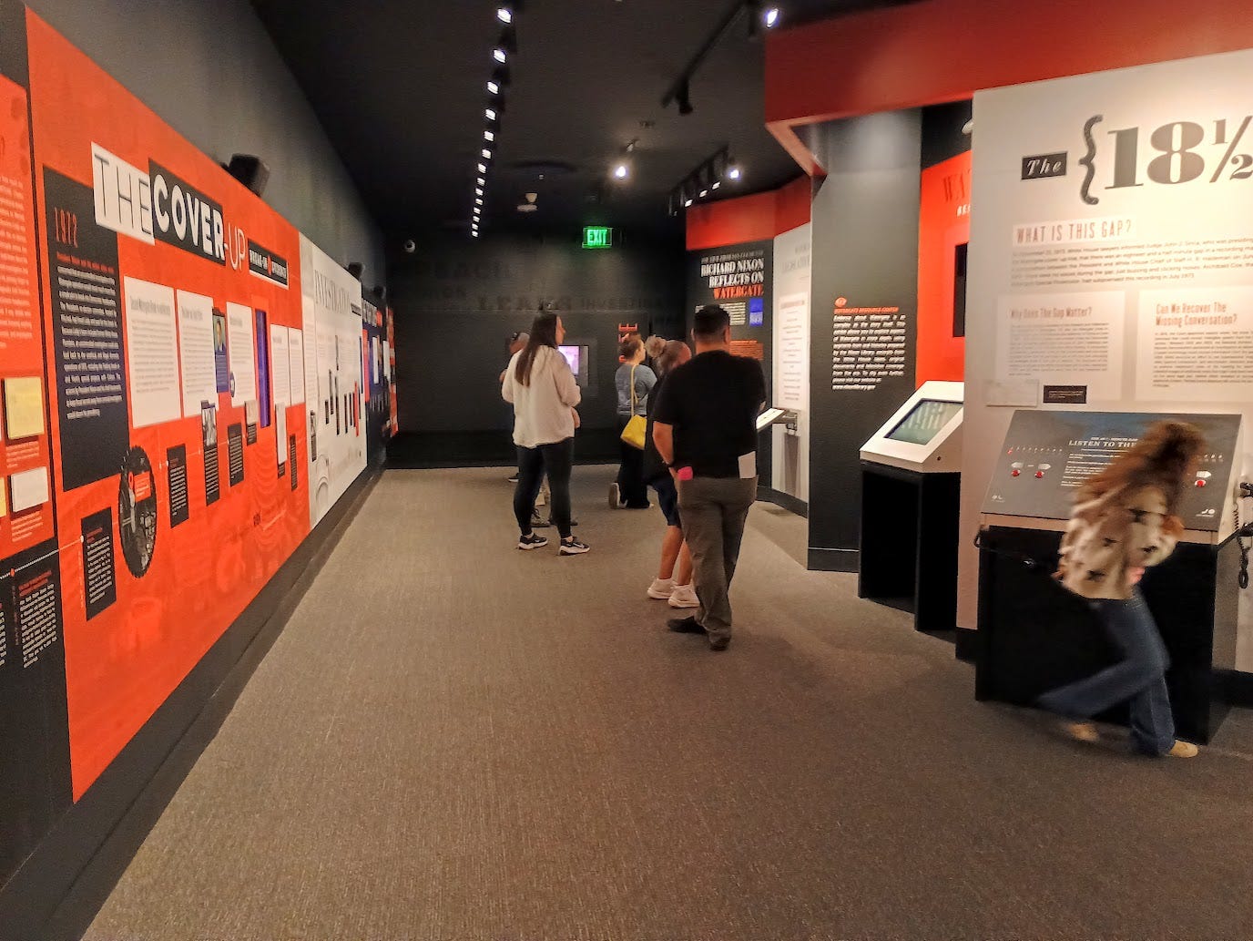 Hallway with exhibits on Watergate in orange and black..