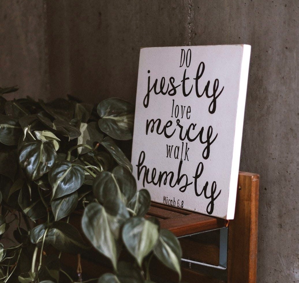 do justly love mercy walk humbly signage leaning on wall beside plants do justly love mercy walk humbly signage leaning on wall beside plants