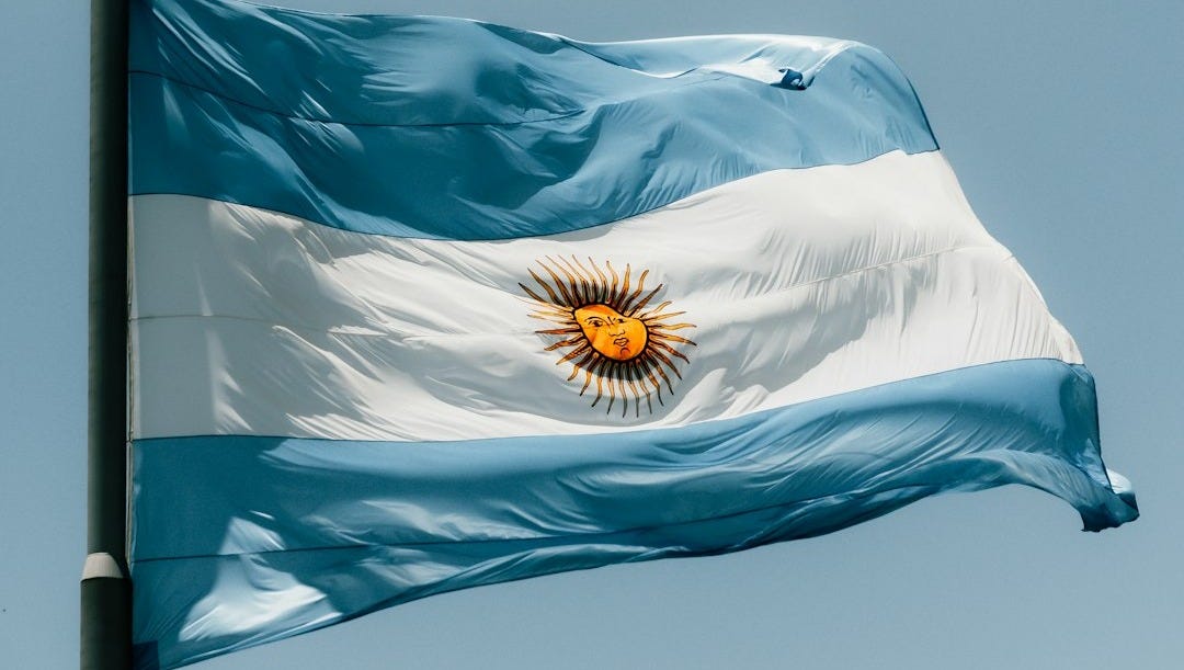 The flag of argentina is flying high in the sky