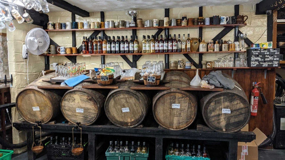 Wooden casks of cider behind the bar of Ye Olde Cider Bar