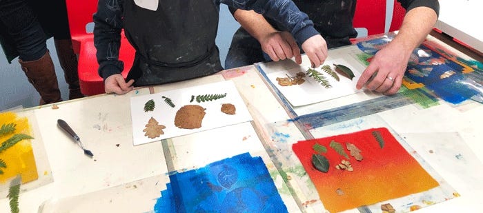 an adult and child using leaves for printmaking