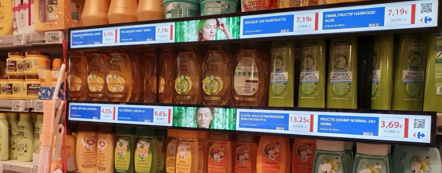 rayon de magasin, avec à la place des etiquettes un long écran avec les prix affichés et des images de femmes