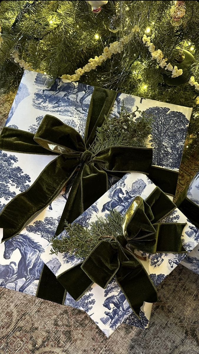 This may contain: presents wrapped in blue and white paper tied to a christmas tree with green bows on them This may contain: presents wrapped in blue and white paper tied to a christmas tree with green bows on them