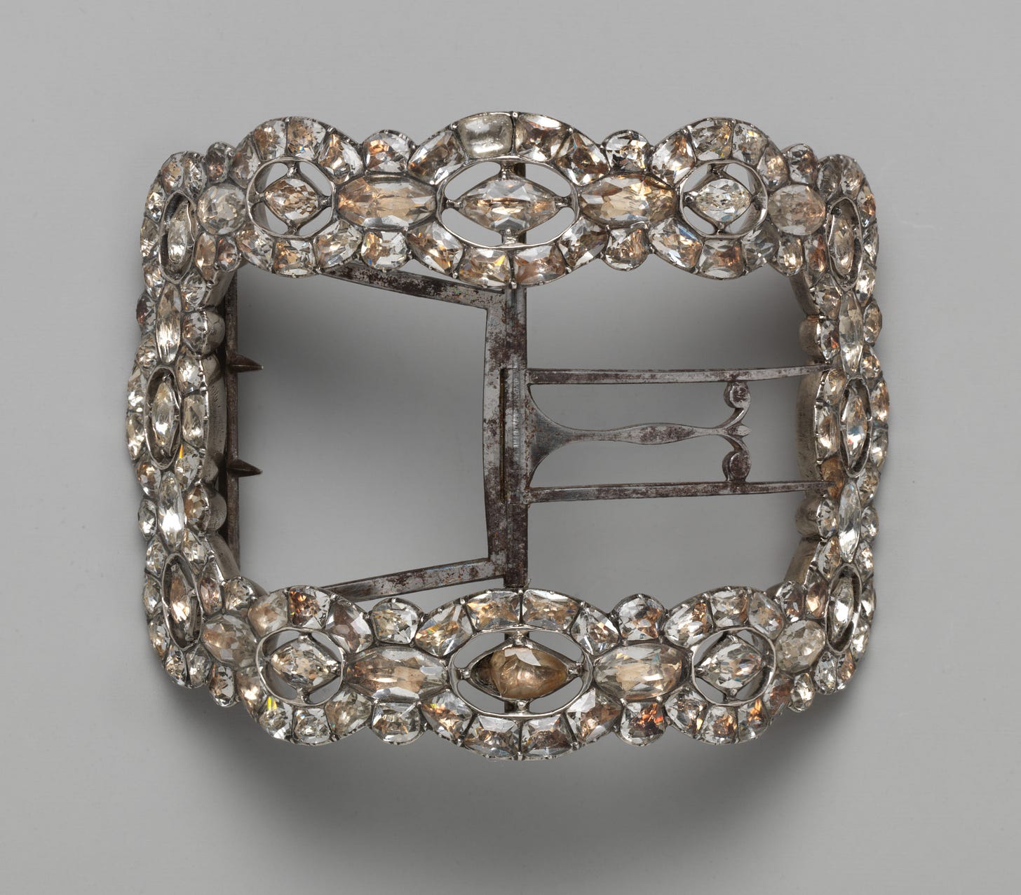 close up of metal shoe buckle encrusted with clear jewels