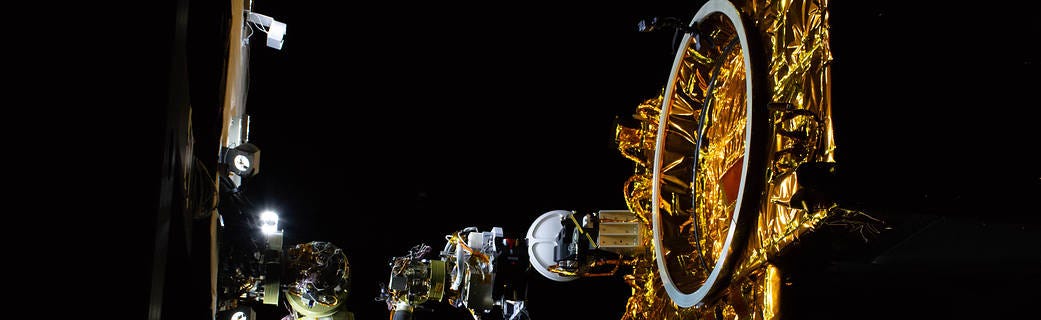  OSAM-1’s Robotic Servicing Arm (left) in the Robotic Operations Center at NASA's Goddard Space Flight Center. The partial model of a client satellite (right) sits on top of a hexapod robot, which helps to simulate zero-gravity movement. Credits: NASA

