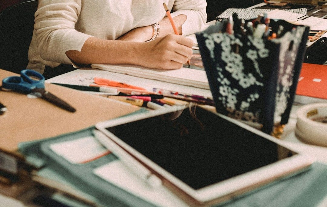 woman in white long sleeve shirt writing on white paper