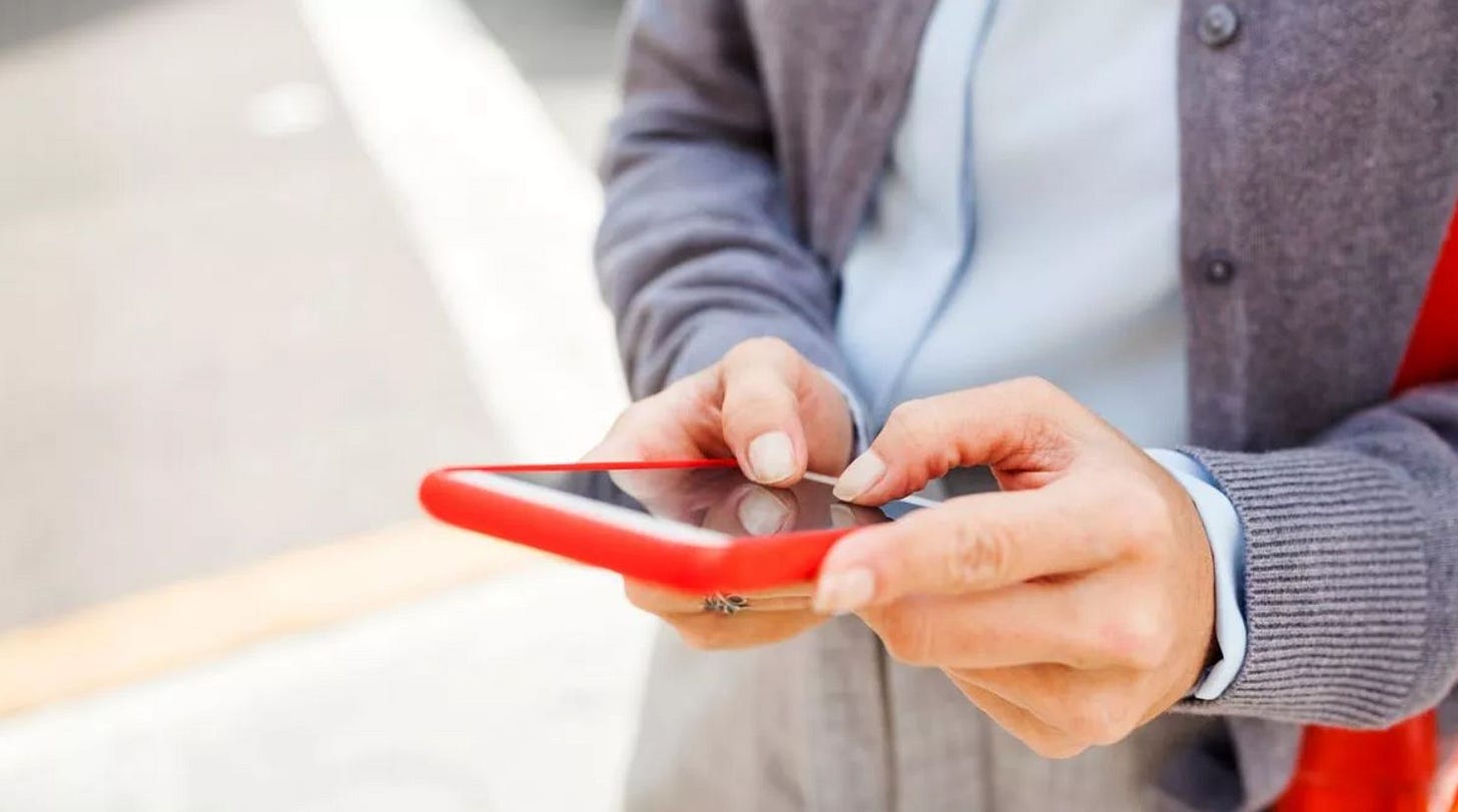 Persons hands holding a red mobile smartphone