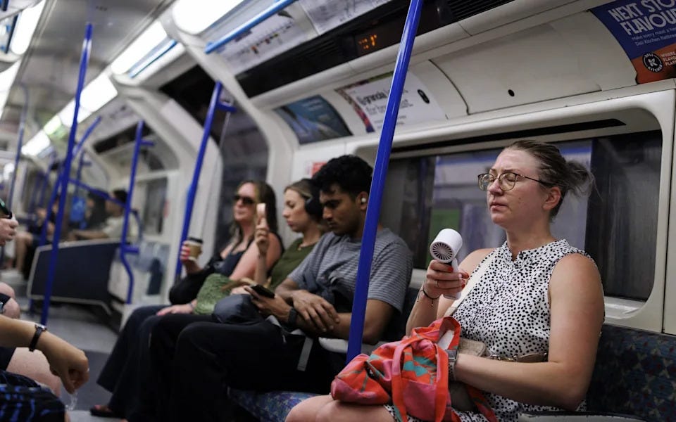 people fanning themselves on an underground train
