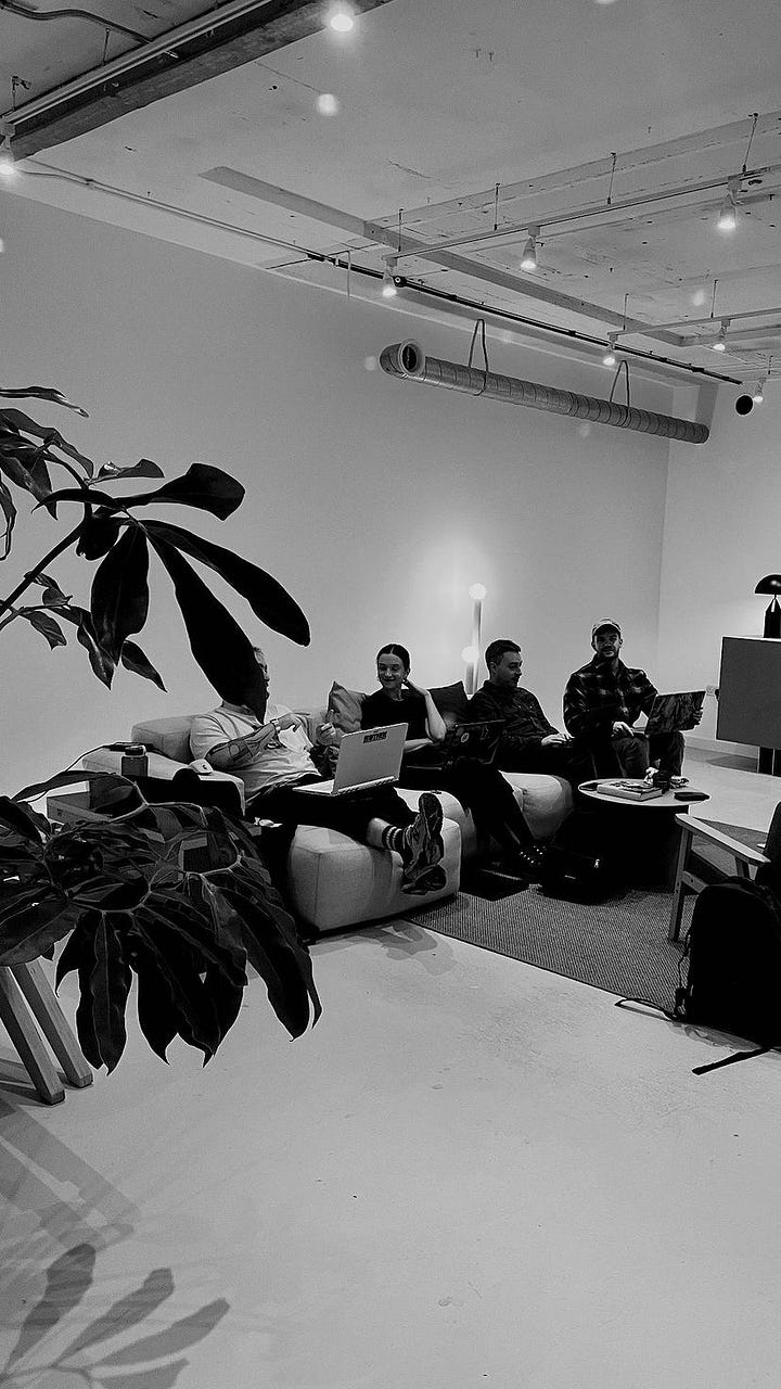 The Midnight team sitting at desks and on the sofa working in the new Studio space