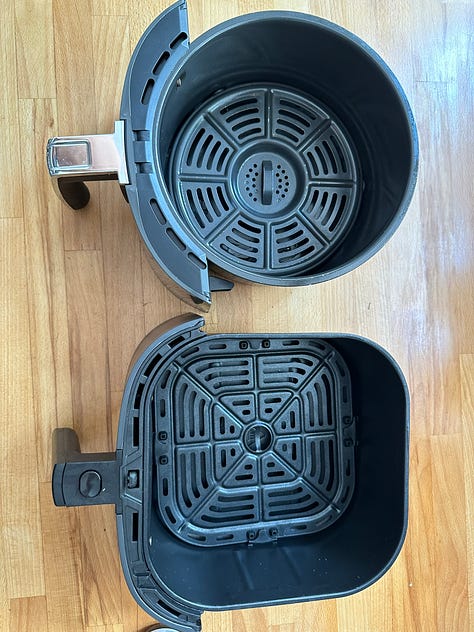 open ninja air fryer; open Cosori airfryer; two air fryer baskets side by side.