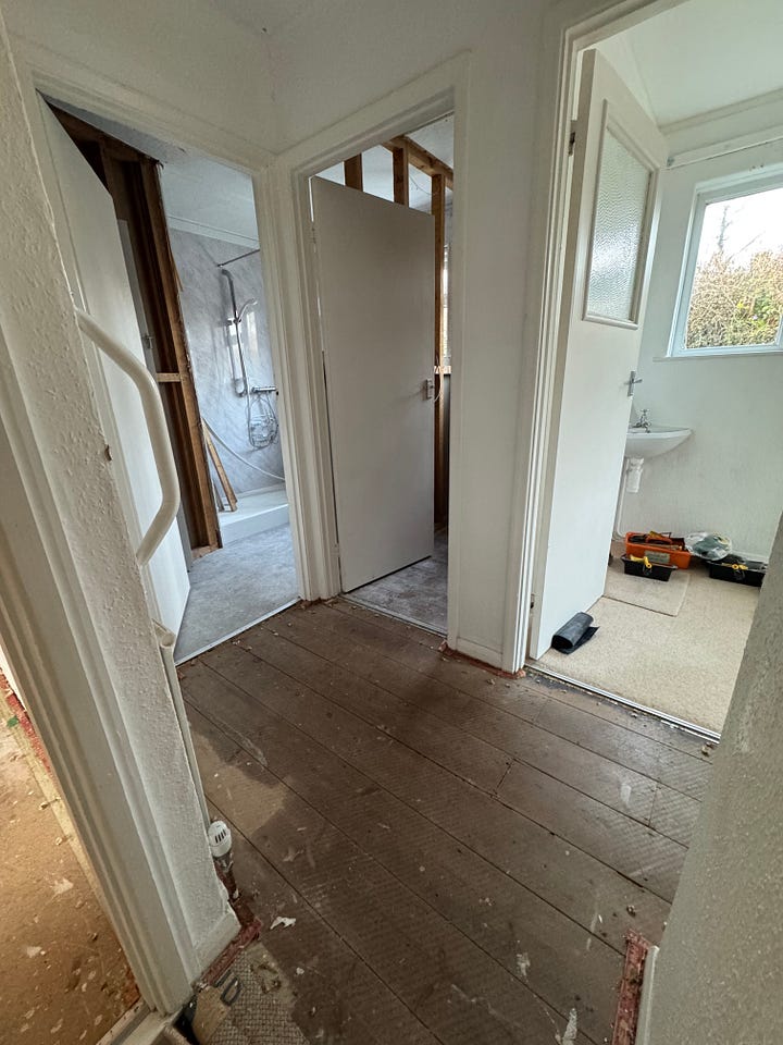 A photo of Gail wearing a dustmask standing in front of a wall where the wallpaper has been removed, and a photograph of old wooden floorboards that have been revealed in the upstairs hallway after she tore up the carpet. 