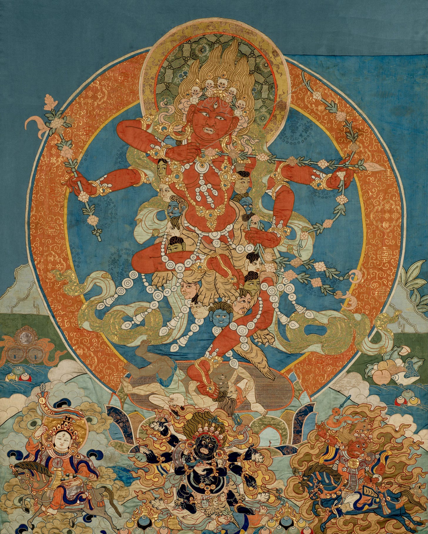 This large-scale appliqué thangka depicts the Vajrayana goddess Kurukulla. Her skin is red, and she is holding a bow with a flower-tipped arrow. She is wearing bone ornaments and dancing on a pile of corpses. A garland of severed heads frames her body. Below is a group of fierce protectors. This large-scale appliqué thangka depicts the Vajrayana goddess Kurukulla. Her skin is red, and she is holding a bow with a flower-tipped arrow. She is wearing bone ornaments and dancing on a pile of corpses. A garland of severed heads frames her body. Below is a group of fierce protectors.
