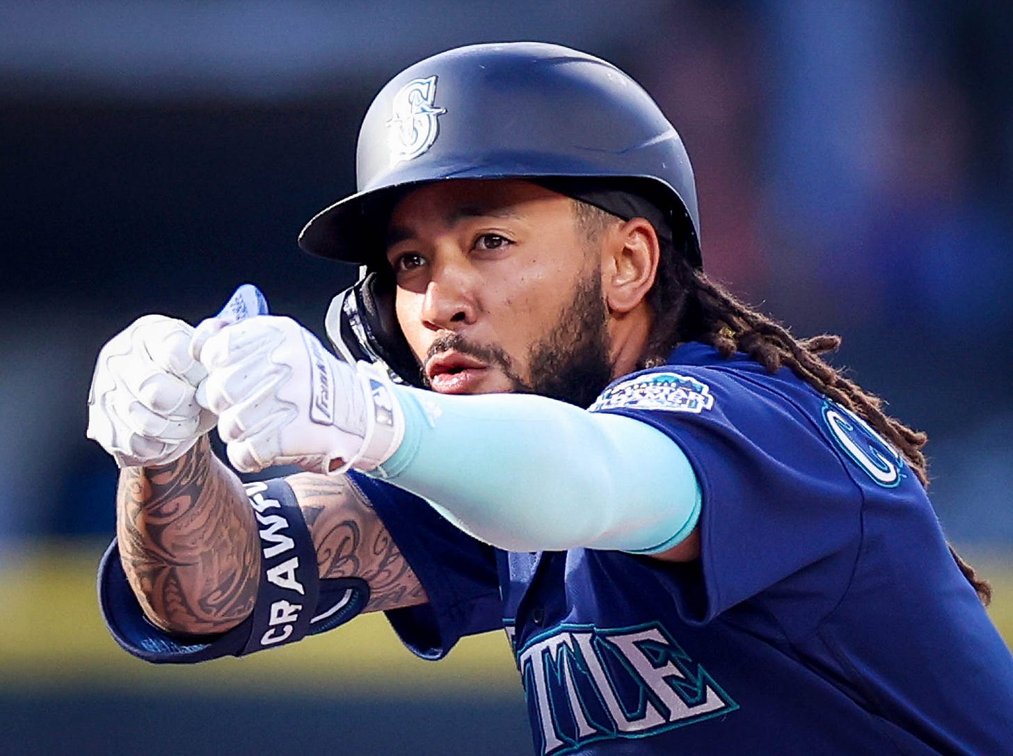 J.P. celebrates towards the dugout from second base, arms outstretched.
